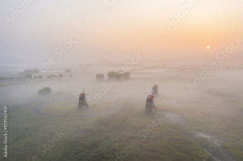 Namdong-gu, Incheon, South Korea - September 21, 2021: Aerial and sunrise view of three windmills at Sorae Wetland Ecological Park with fog and the sun photo