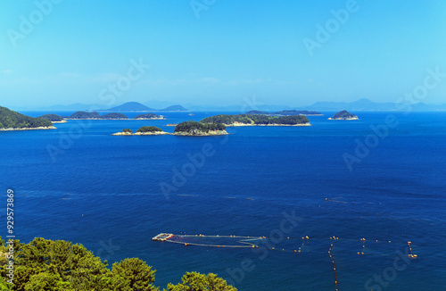 Yogjido Island, Tongyeong-si, Gyeongsangnam-do, South Korea - May 2, 2022: High angle and spring view of fishing net on the sea against uninhabited island and horizon photo