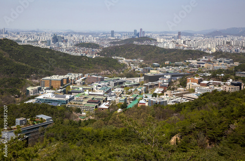 Gwanak-gu, Seoul, South Korea - April 15, 2022: High angle and spring view of buildings at Seoul National University against downtown Seoul at Gwanaksan Mountain