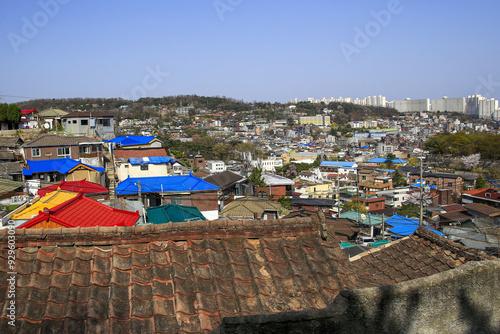 Myeongnyun-dong, Jongno-gu, Seoul, South Korea - April 10, 2022: Spring view of tile roof of detached houses on the hill at Bukjeong Village near Seoul Fortress and Waryong Park photo