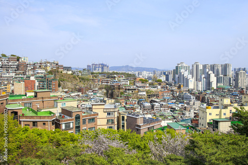 Jongno-gu, Seoul, South Korea - April 12, 2022: High angle view of townhouses and apartments on the hill near Naksan Park in spring