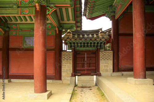 Jongno-gu, Seoul, South Korea - May 8, 2022: Front view of wood pillars and an entrance door with tile roof and Dancheong(traditional multicolored paintwork) at Gyeonghuigung Palace photo