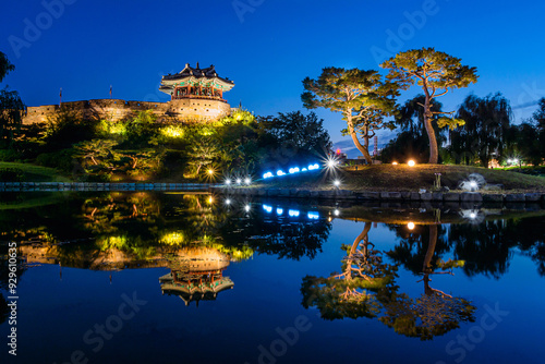 Paldal-gu, Suwon-si, Gyeonggi-do, South Korea - August 18, 2019: Night view of Yongyeon Lake and pine trees with reflection on water against Banghwasuryujeong Pavilion of Suwon Hwaseong Fortress photo