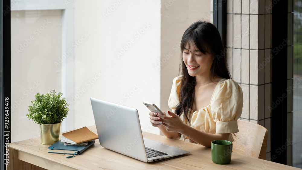 Asian woman working on her smart phone in a modern coffee shop Asian woman working on her smart phone in a modern coffee shop