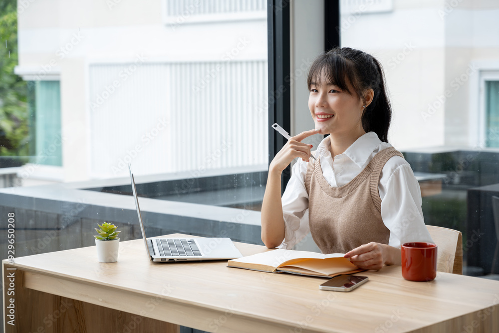 Asian businesswoman taking notes at a meeting desk in an office. Asian businesswoman taking notes at a meeting desk in an office.