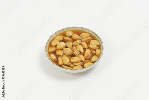 Close-up of pickled garlic roots in a small bowl on white floor, South Korea 