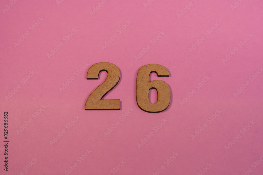 Number 26 in wood on a pink background Number 26 in wood on a pink background