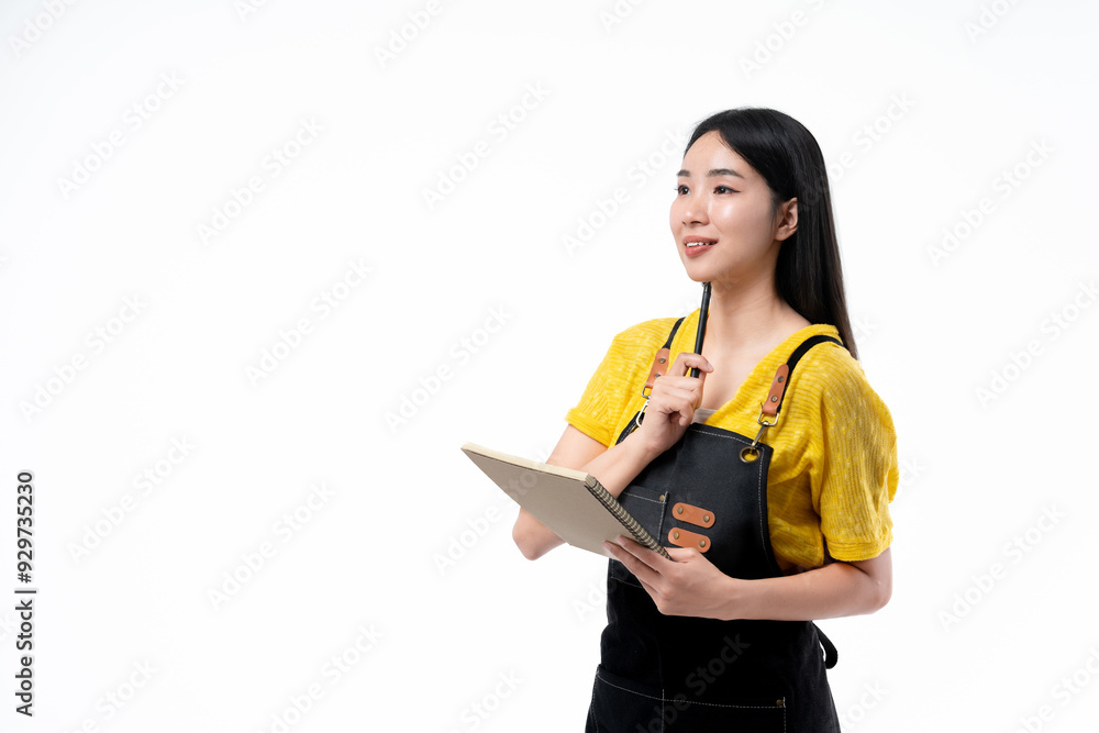 Young chef asian woman wearing kitchen apron holding notepad recipe cooking book and pen on white background. Young chef asian woman wearing kitchen apron holding notepad recipe cooking book and pen on white background.