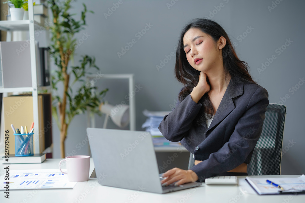 Young asian businesswoman is experiencing neck pain while working on her laptop at her desk Young asian businesswoman is experiencing neck pain while working on her laptop at her desk