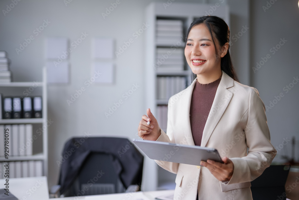 Young manager woman is holding digital tablet and smiling while working on new project in modern office Young manager woman is holding digital tablet and smiling while working on new project in modern office