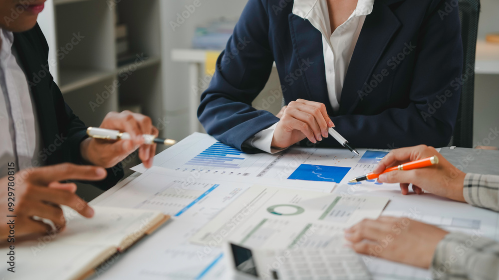 Business team having a meeting and analyzing financial data using graphs and charts, brainstorming and discussing new strategies Business team having a meeting and analyzing financial data using graphs and charts, brainstorming and discussing new strategies