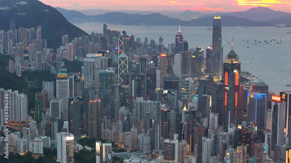 Aerial view drone video City landscape of the famous travel landmark cityscape. buildings with light and transportation at Victoria Harbour skyline and Kowloon at sunset along Hong Kong Island China. Aerial view drone video City landscape of the famous travel landmark cityscape. buildings with light and transportation at Victoria Harbour skyline and Kowloon at sunset along Hong Kong Island China.