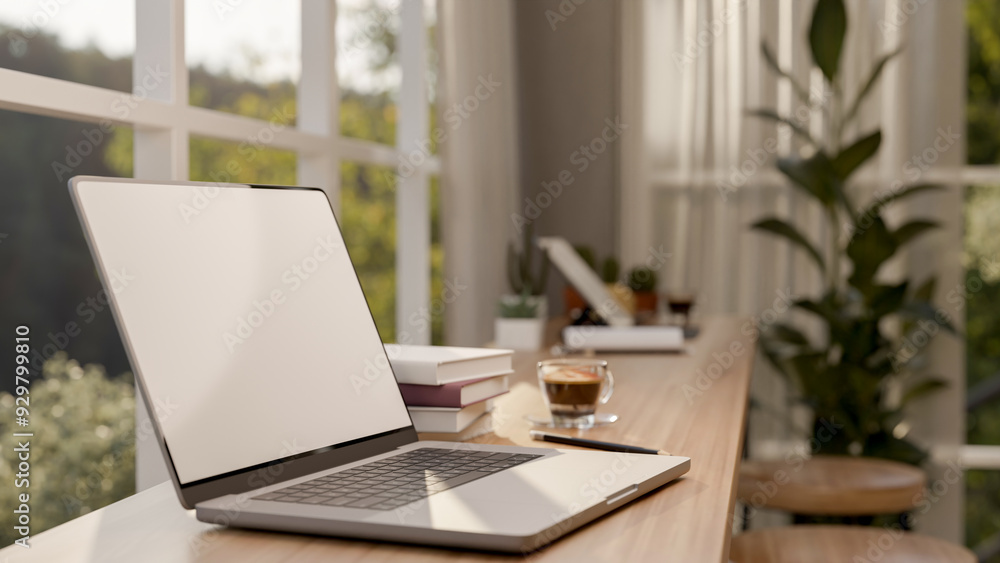 A close-up image of a laptop computer on a wooden table against the window in a minimalist cafe. A close-up image of a laptop computer on a wooden table against the window in a minimalist cafe.