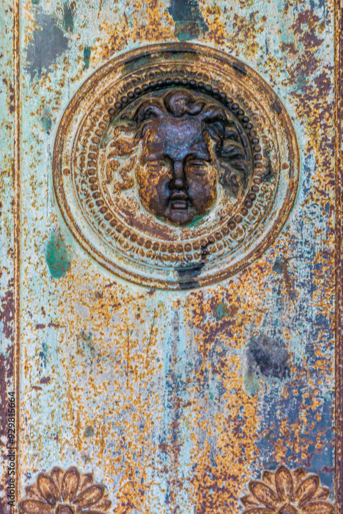 Bas relief of an angel's head on an old rusty church door Bas relief of an angel's head on an old rusty church door