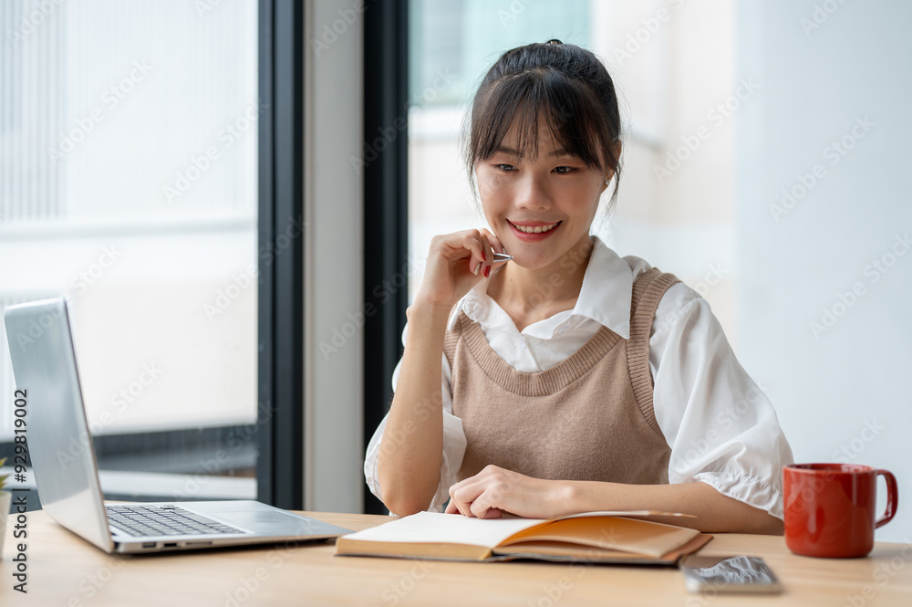 A beautiful Asian woman is daydreaming, thinking about something while working in the office. A beautiful Asian woman is daydreaming, thinking about something while working in the office.