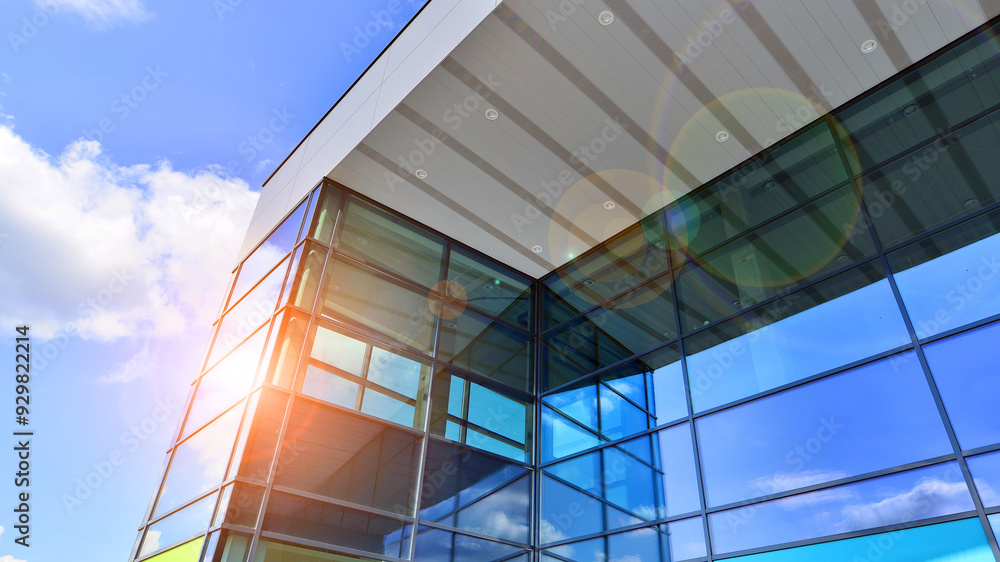 Fragment of a modern building made of steel and glass. Abstract modern commercial architecture fragment. Walls made of shiny glass and steel under blue sky. Fragment of a modern building made of steel and glass. Abstract modern commercial architecture fragment. Walls made of shiny glass and steel under blue sky.