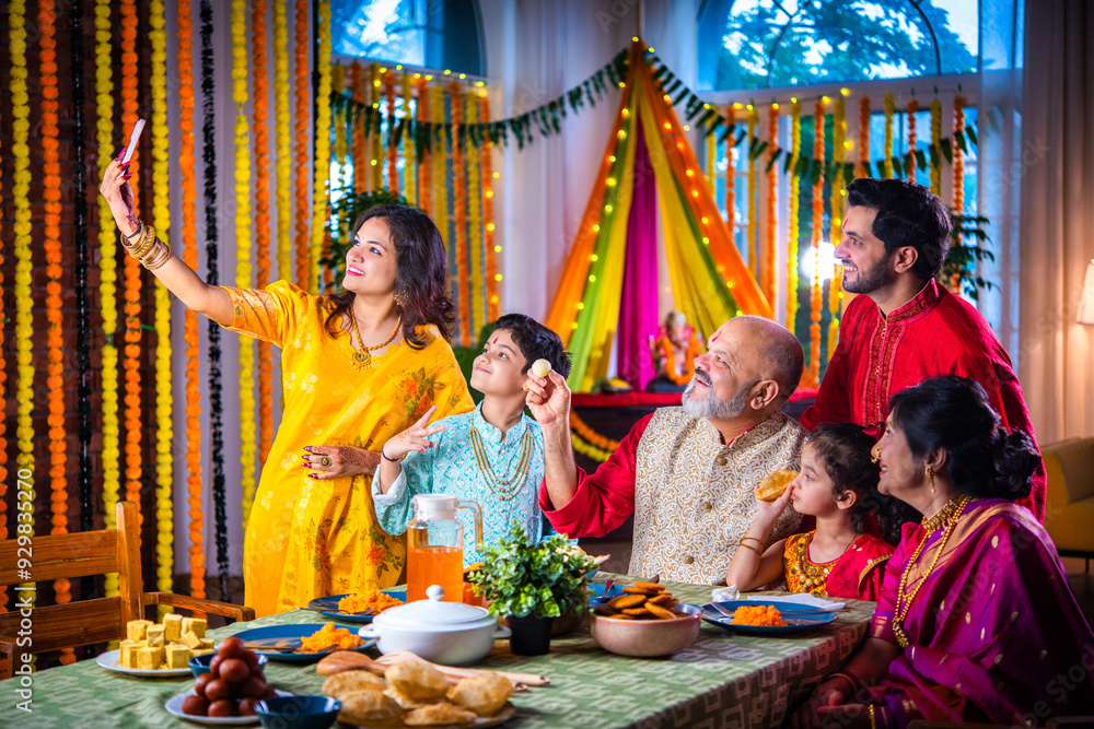 Portrait of happy Indian family in traditional outfit celebrating Diwali together at home eating food. Portrait of happy Indian family in traditional outfit celebrating Diwali together at home eating food.