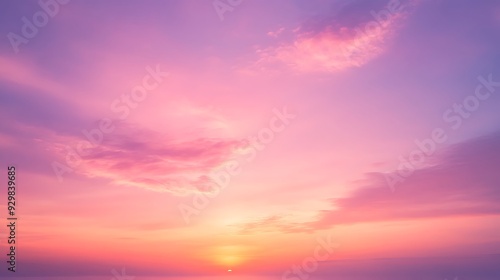 Soft pastel pink and orange sunset sky with clouds.