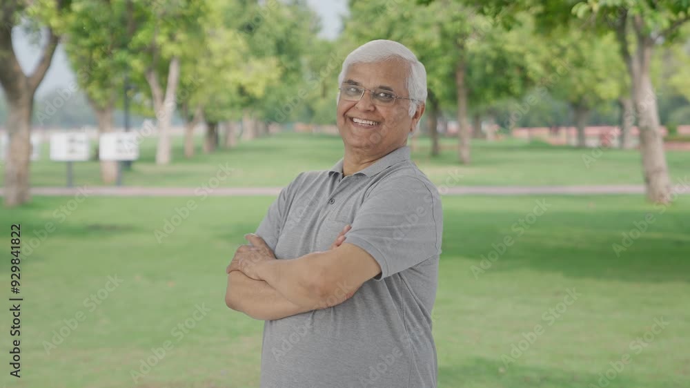 Portrait of Happy Indian old man standing crossed hands in park Portrait of Happy Indian old man standing crossed hands in park