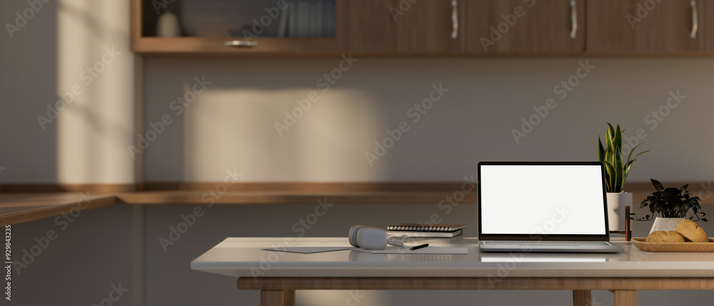 A laptop computer mockup and decor on a kitchen table in a contemporary, minimalist kitchen. A laptop computer mockup and decor on a kitchen table in a contemporary, minimalist kitchen.