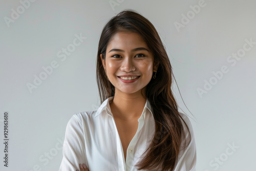 casual portrait features a young woman with straight hair and a soft smile, highlighted by a crisp white shirt and a bright, clean background.