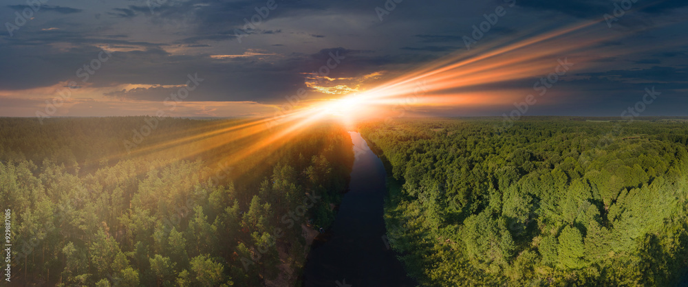 Obraz premium View from drone, panorama view of the forest and fields, top view, orange sky and gray clouds, sun at sunset