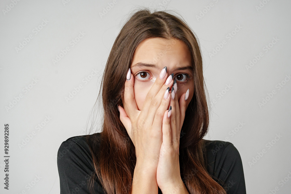 Young Woman Covering Her Face With Hands While Looking Scared Young Woman Covering Her Face With Hands While Looking Scared