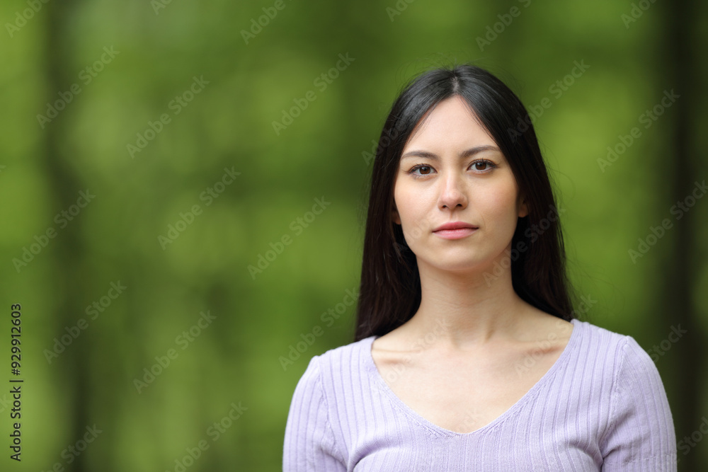 Serious asian woman looking at you on green Serious asian woman looking at you on green