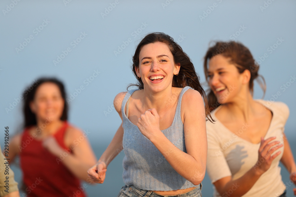 Three happy friends running on the beach enjoying vacation Three happy friends running on the beach enjoying vacation