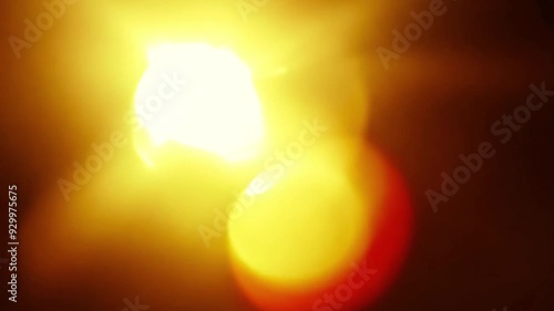 Sunlight flare with a glowing warm yellow and red on a black background
