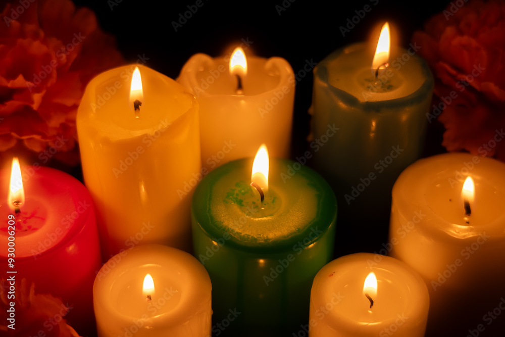 Candles burning brightly in the center, surrounded by marigolds on a dark background Candles burning brightly in the center, surrounded by marigolds on a dark background