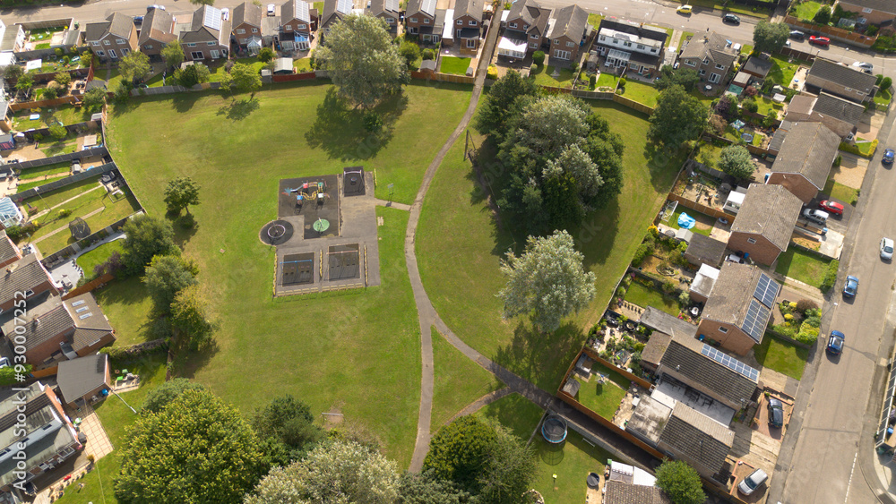 Fototapeta premium An aerial photograph looking down on a park with a small children's play area set amongst lowrise housing