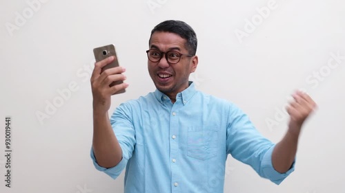 A man showing excited and full of joy when looking at his mobile phone