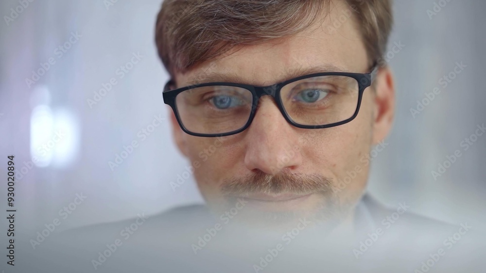 Businessman with glasses looking intently obscured partially by a translucent surface of laptop. Business concept Businessman with glasses looking intently obscured partially by a translucent surface of laptop. Business concept