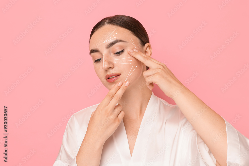 Beautiful young woman doing face massage with fingers on pink background. Lines on skin showing directions of motion