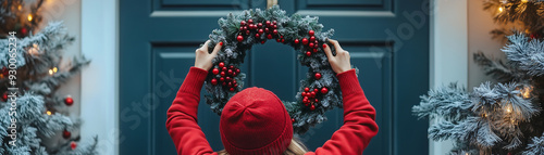 A person in a festive wreath on a door, surrounded by frosted Christmas trees with lights.