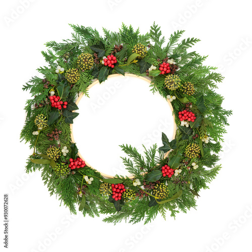 Christmas winter green wreath natural flora, holly berry, ivy, mistletoe, cedar fir on white wooden frame. Nature natural design for Yule Noel Xmas. Pagan Druid symbol.