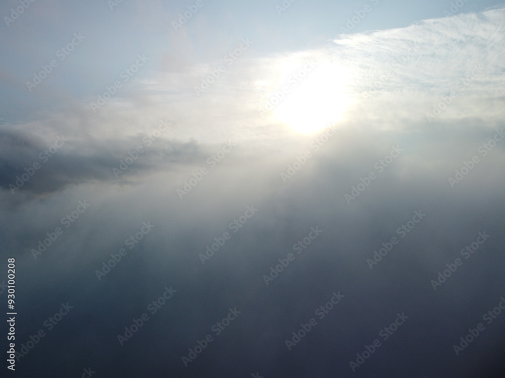 Naklejka premium Aerial view. Blue sky sun and fog over calm sea. The drone flies over foggy and fluffy clouds. Abstract aerial nature summer ocean sunset sea and sky background. Vacation, travel and holiday concept.