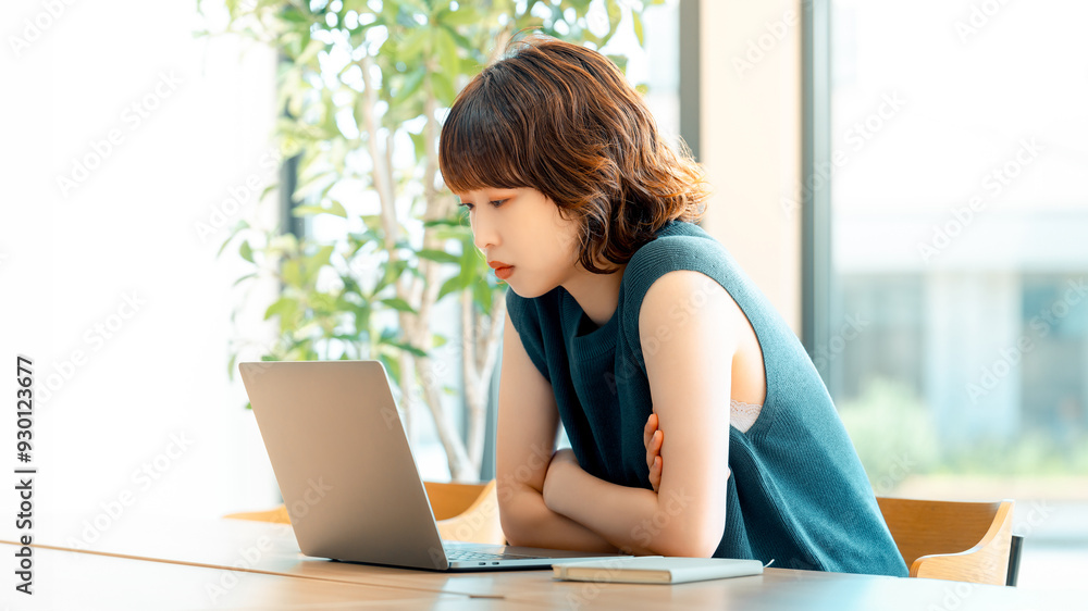 パソコンを使いながら考える日本人女性 パソコンを使いながら考える日本人女性