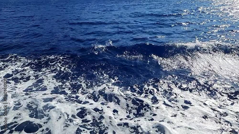 slow motion of a dark blue sea and diverging waves from a moving ship slow motion of a dark blue sea and diverging waves from a moving ship
