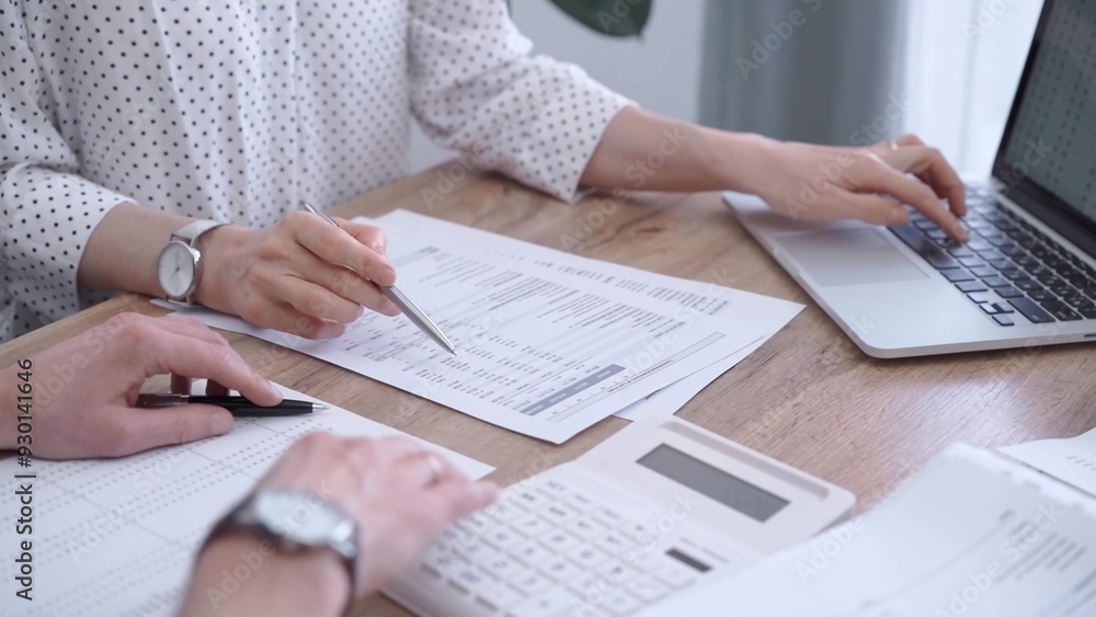 Professional female bookkeeper or auditor are working on business finances with a colleague, using calculator and laptop. Finance audit and taxes Professional female bookkeeper or auditor are working on business finances with a colleague, using calculator and laptop. Finance audit and taxes