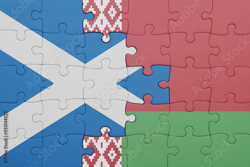 puzzle with the colourful national flag of belarus and flag of scotland.