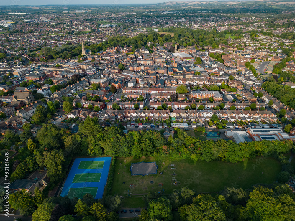 Swindon old town with church at sunset in summer. High altitude aerial view from Town Gardens. Recreational grounds with tennis court. Panoramic view of the town.