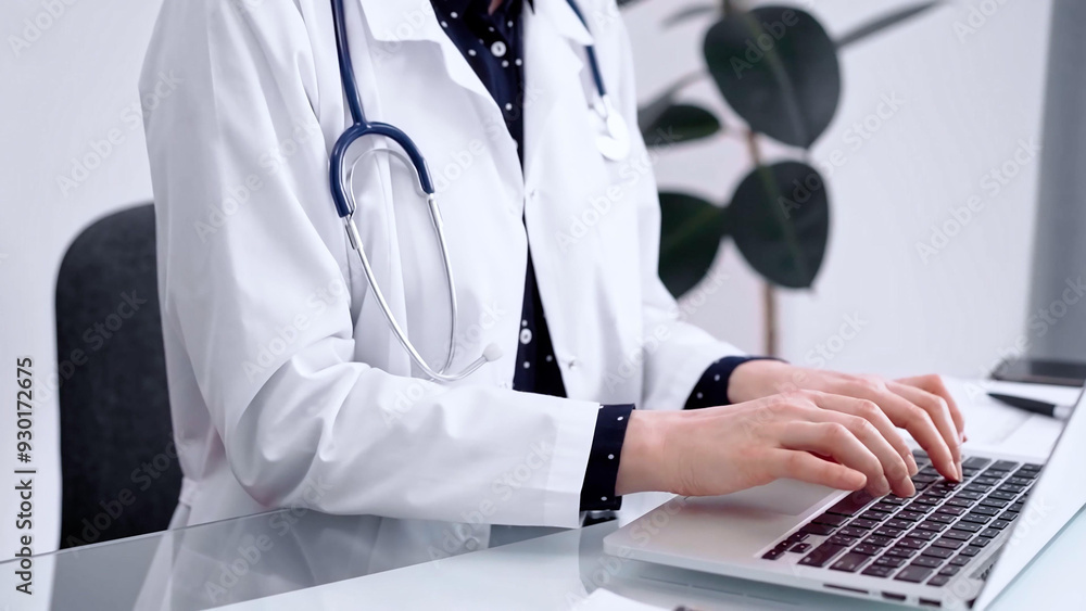 Doctor woman is using laptop computer at glass table in clinic. Medicine and pharmacy concept Doctor woman is using laptop computer at glass table in clinic. Medicine and pharmacy concept