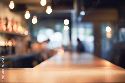 Out of focus background of pub interior with wooden bar. In the background appears a blurred unrecognizable person.