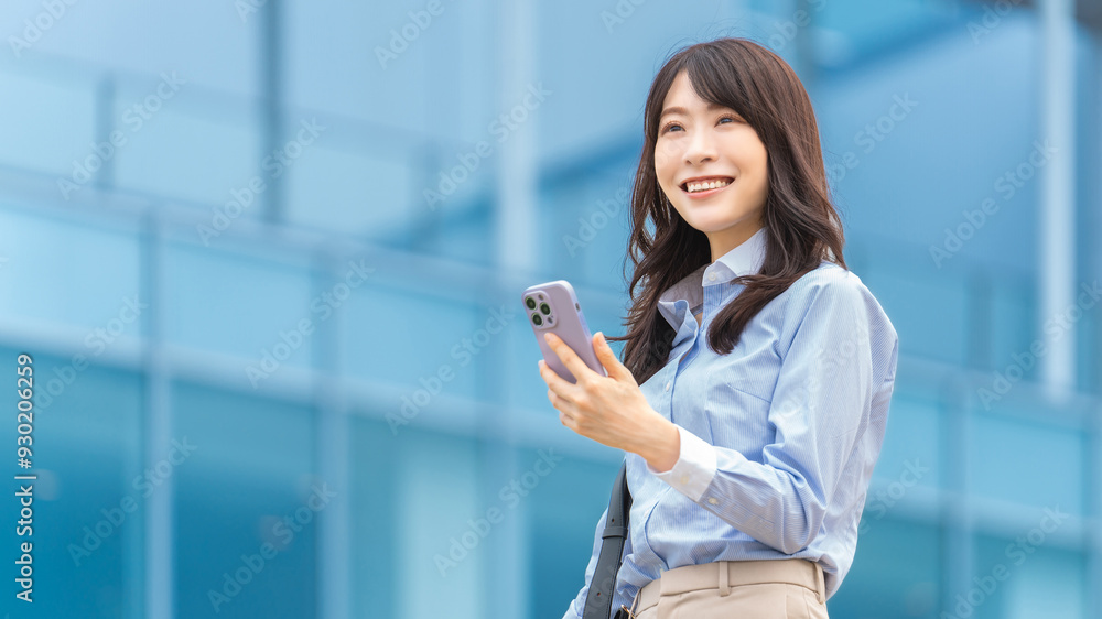 スマホを持つ笑顔の日本人ビジネスウーマン スマホを持つ笑顔の日本人ビジネスウーマン