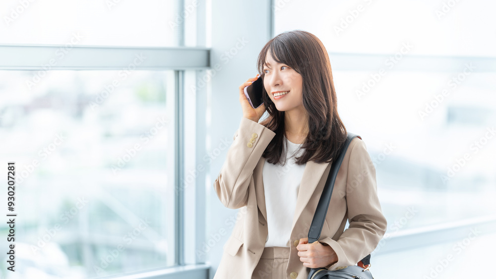 スマホで話す笑顔の日本人ビジネスウーマン スマホで話す笑顔の日本人ビジネスウーマン
