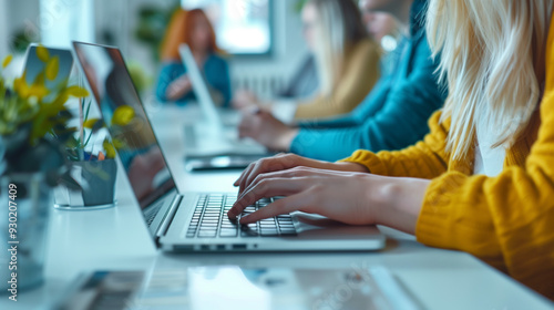 Female worker is typing on a laptop in a meeting situation.