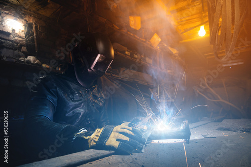 Close up of welder working on welding iron in old garage, workshop