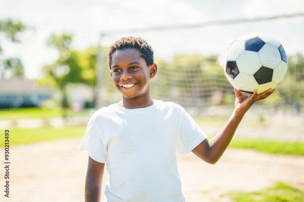 Young kid playing soccer on a playfield Young kid playing soccer on a playfield